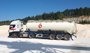 Un tracteur attelé d'une semi type citerne à pulvérulent.