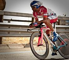 A cyclist competing on a specialised time-trial bicycle