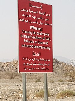 Sign board at border point Hatta/Madam road passing through Mahdah