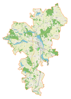 Mapa konturowa gminy Olecko, blisko centrum na lewo znajduje się owalna plamka nieco zaostrzona i wystająca na lewo w swoim dolnym rogu z opisem „Jezioro Dobskie”