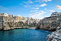 Polignano a Mare op de kliffen boven zee. In het midden is een klein strand te zien.