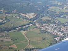 Eine kleine Stadt von land- und forstwirtschaftlich genutzten Flächen umgeben, durchzogen von Flüssen und Straßen.