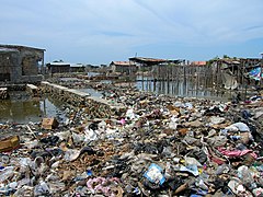 Solid waste bought back from collection trucks to create fill for a road in Cap-Haitien.