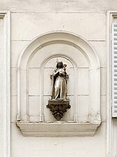 Statue d'une Vierge à l'Enfant dans une niche murale.