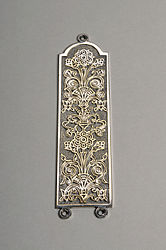 Silver fingerplate with a stylised flower design.