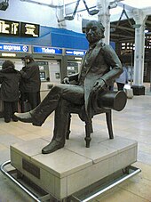Una estatua negra de un hombre sentado con un sombrero de copa