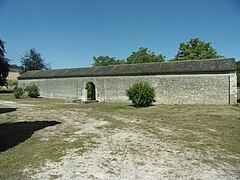 Photographie d'un long mur sans décor percé d'une porte.