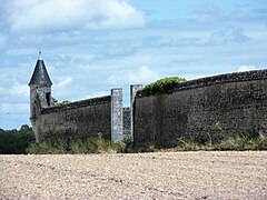 Photographie en couleurs d'un mur terminé par une échauguette.