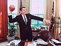 Presidentti Ronald Reagan jalkapallo kädessä Oval Officessa.