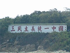 金門大膽島上面向廈門的「三民主義統一中國」心戰牆，1986年8月金防部司令趙萬富上將令烈嶼師長龔力少將興建，翌年同因三七事件去職。