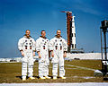 Schweickart (vľavo), Scott (v strede) a McDivitt (vpravo) pózujú pred raketou Saturn V