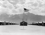 Typical interior scene in a Manzanar barrack apartment. Note the cloth partition separating one apartment from another, lending a small amount of privacy 30 June 1942