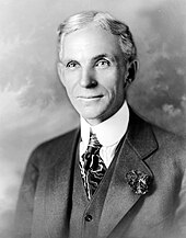 Black and white photographic portrait of Henry Ford in formal uniform and looking to the right