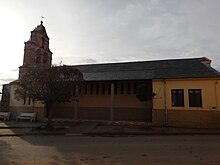 Vista frontal de la iglesia de San Juan de Torres con el campanar a la izquierda. Es una iglesia pequeña.