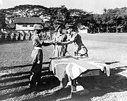 英國軍隊指揮官多吉·湯頓（Doidge Taunton）於婆羅洲接受1名日本軍官所遞交軍刀。