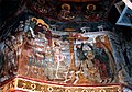 Nástěnná malba v kostele sv. Jiří zdůrazňuje dobrovolnost Kristovy oběti tím, že Ježíš sám stoupá na kříž