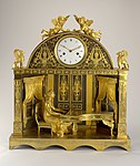 Clock; 1807–1810; fire-gilt bronze, blackened bronze, enameled metal (dial), blued steel (hands); glass; 56 x 49.7 x 18.5 cm; Cooper Hewitt, Smithsonian Design Museum (New York City)