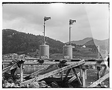 A pair of unlit Wells lights, on a wooden jetty