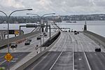 A long floating bridge crossing a lake in a suburban area