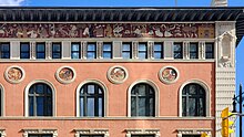 Close up detail of the intricate mosaic artwork along the top of the Birks Building. In it are many characters doing things like riding a chariot, holding scrolls, digging, or conversing.