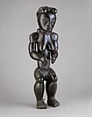 Statue d'ancêtre féminine eyema byeri, gardien de reliquaire. Fang « du Sud », Okak. République gabonaise ou Guinée équatoriale, 19e-début 20e. Bois, métal, H. 64 cm[35]