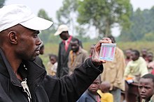 Technician holds color-coded card with water testing standards