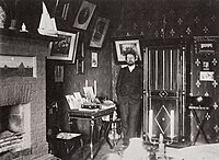 Tsjechov in zijn werkkamer in de witte datsja in Jalta, 1900 of 1901; links de schouw met het landschapje (Hooimijten in maanlicht) dat Levitan voor hem schilderde, omdat Tsjechov het platteland miste