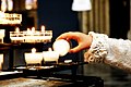 A child lighting a votive candle at the Catholic Christian Cathedral of St. Michael and St. Gudula in Brussels