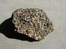 A speckled rock with black (ilmenite) and white (apatite) grains