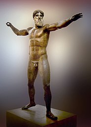 Déu del cap Artemísion (2,10 metres) circa 460 aC, representat amb el moviment de llançar el trident, porta la barba pròpia de l'època amb rínxols i té les conques dels ulls buides.