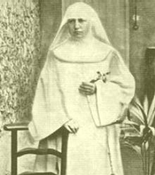 A nun in a white habit holding a crucifix