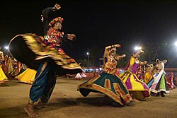 Vyrai ir moterys šoka garbą šokį per Navaratrės ceremoniją Ahmedabade