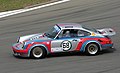 14. 1974-es Porsche 911 Carrera RSR az AvD 2011‑es oldtimer nagydíján a németországi Nürburgringen, a Mercedes Aréna előtt (javítás)/(csere)