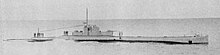 a black and white image of a submarine underway on the surface