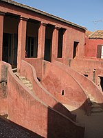 A red building with stairs and columns