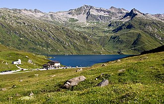 Hospiz mit Lai da Sontga Maria sowie dem Seitental zum See Val Rondadura, darüber als höchster Punkt am Horizont Piz Lai Blau