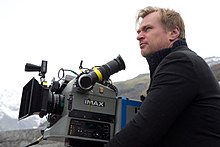 Photographie d'un homme à côté d'une caméra IMAX.