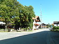 Dorfstraße in Grainbach mit der Traditionsgaststätte Maurer (links im Bild); vor deren Biergarten der Samerbrunnen, flankiert von zwei Sitzbänken