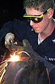 A U.S. Navy sailor using welding glasses