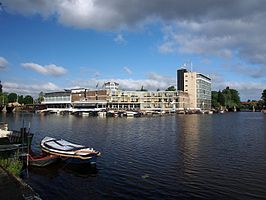 De Kom gezien vanaf het Amstelkanaal, met op de achtergrond het Apollo Hotel.