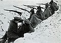 Dentista trabalhando numa trincheira na Polônia, 1915. Os soldados no plano de fundo usam pickelhauben.