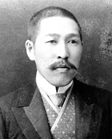 Black-and-white photo of a Japanese man with a mustache and short hair