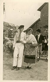 Pierre Desproges, jeune homme, en spectateur moqueur lors d'un défilé costumé organisé à l'occasion de la kermesse de l'école du château de Châlus-Chabrol, le 26 septembre 1958