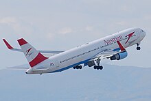 Vue de quart arrière d'un 767 d'Austrian Airlines au décollage, avec des winglets rouges.