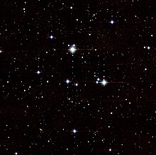 Snímek ukazující středovou část hvězdokupy s desítkami velmi jasných hvězd a stovkami slabých hvězd na pozadí