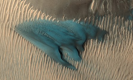 A dune on Mars appears in false colors blue. In false colour colours yellow to blue represent warmer to colder regolith.[52]