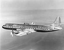 Image of a Lockheed L-188 Electra aircraft in level flight along a coastline