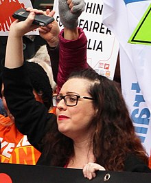 Van Badham raising one arm at a Melbourne protest