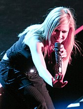 Woman wearing a black gown and sining in to a microphone.