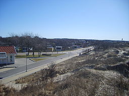 Sanddyner och kolonistugor utmed stranden